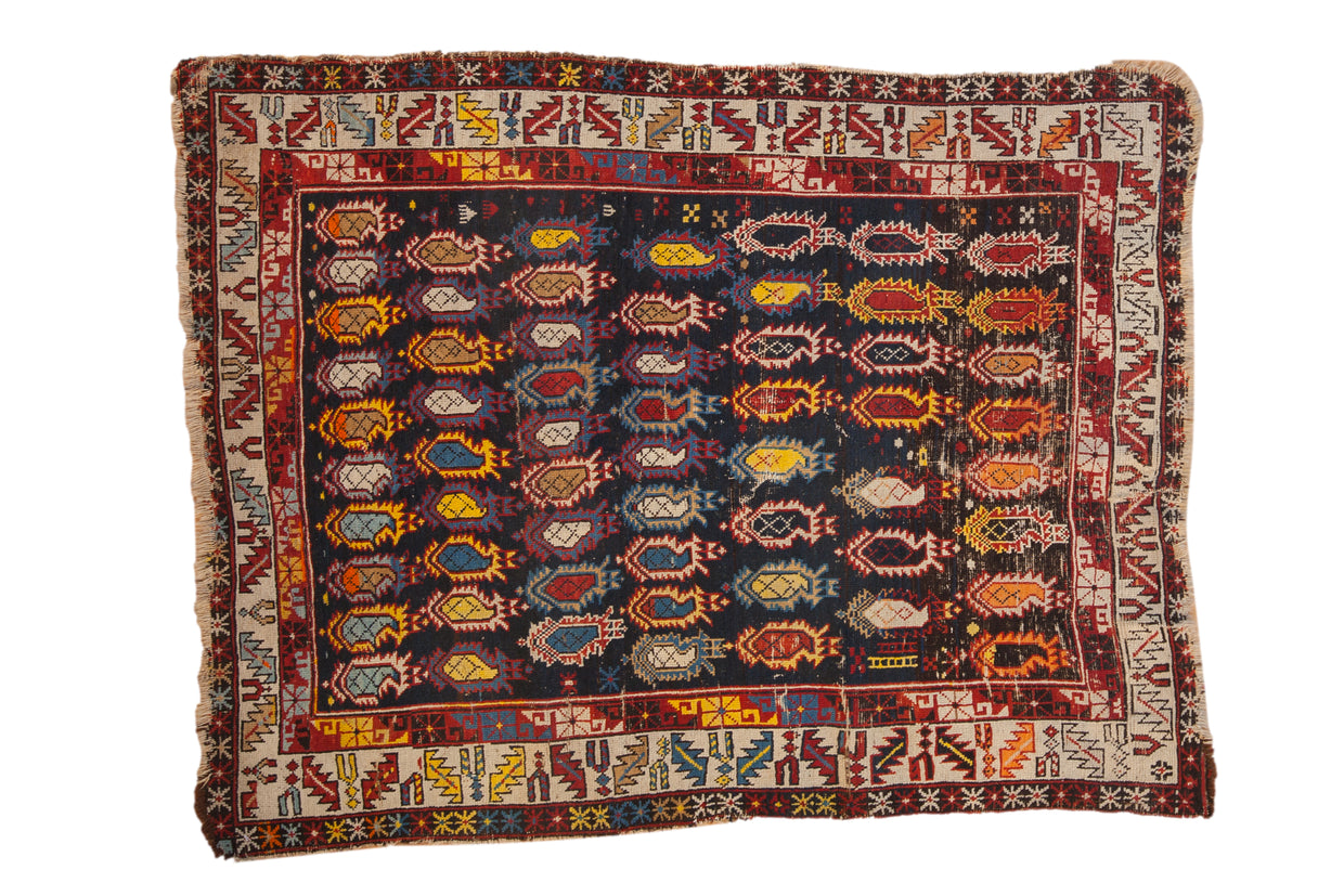 Antique Caucasian rug with a densely ornamented field of colorful boteh on a navy ground and geometric borders.