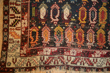 The worn corner of an antique Caucasian rug, detailing its tribal borders and hand-knotted texture.