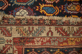 The worn hand-knotted end of an antique Caucasian rug showing its geometric kilim border.