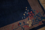 A close view of the vintage Art Deco rug's corner, showing the secured fringe and floral sprays.