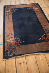 Vintage Art Deco rug corner with delicate floral sprays framing the dark cobalt blue field.