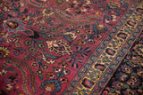 Detailed view of floral blossoms and scrolling vines on the aubergine purple field of a Persian carpet.
