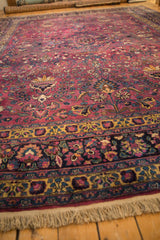 Intricate planters and floral patterns on the purple pile of a vintage Meshed carpet, seen from a low angle.