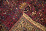 Folded corner of a vintage Persian Meshed rug showing its hand-knotted pile and reinforced fringe.