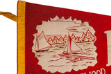 Close-up of the vintage pennant's red felt texture and off-white sailboat illustration.