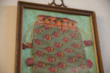 Refined silk rust and saffron stylized motifs with pom-pom on framed antique pouch.