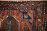 A Karaja rug corner featuring the starburst floral border in sapphire blue and madder red.