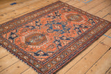 Angled view of a vintage Karaja rug displaying its triple medallion design and geometric borders.