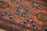 Hook and latch motifs outlining a sapphire blue medallion on the red field of a vintage Karaja rug.