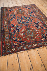Angled perspective of a vintage Karaja rug's triple medallion and starburst border.
