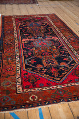 Vintage Kurdish Hamadan rug's navy field, showcasing intricate tendrils and gem-tone floral patterns.