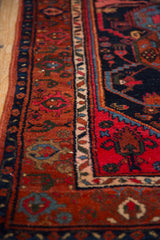 Vintage Kurdish Hamadan rug with geometric tendrils on rust-red field and blue, ivory border.