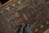 Symbolic cypress and vase motifs on the navy blue field of a collector's antique Tehran rug.