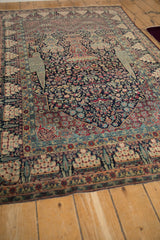 Angled perspective of an antique Tehran rug, showcasing its dense floral field and symbolic borders.