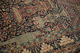 Symbolic pomegranate vessels and cypress tree motifs on a navy blue collector's Tehran rug.