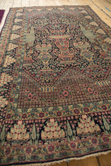 Low-angle view of a collector's Tehran rug, showcasing the unidirectional design with its central vase.