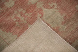 The hand-knotted reverse and machine-bound edge of a distressed vintage Oushak rug.