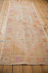 Angled view down the length of a distressed Oushak runner highlighting its soft, time-worn texture.