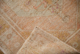 Corner view of a vintage Oushak rug showing the woven back and distressed pile texture.