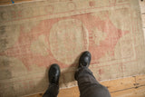 Overhead view showing the scale and soft, worn texture of a distressed Oushak rug in blush and sand.
