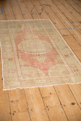 Distressed vintage Oushak runner with a blush medallion and sand field seen from a high angle.