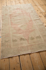 Angled view of a distressed Oushak runner highlighting its even wear and faded blush palette.