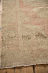 Detail of the intact side cord selvage and low, worn pile on a distressed Oushak rug.
