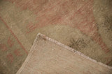 A view of the vintage Oushak's hand-knotted foundation and secured binding on its reverse side.
