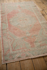 Angled view of a distressed Oushak runner, showcasing its worn texture and soft colors.