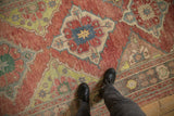 A view highlighting the distressed pile and diamond medallion of a vintage Oushak runner.