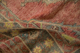 Supple hand-knotted pile of a distressed Oushak rug with ruby, green, and yellow tones.