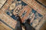 Overhead look at the distressed, short pile texture of a vintage square Oushak rug.