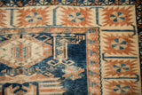 Close-up of the distressed Oushak rug's corner, highlighting the serrated palmettes and indigo blue field.