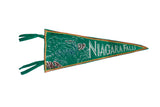 Vintage green felt Niagara Falls pennant with a white graphic and a red and gold corded edge.