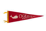 Vintage Ocean Beach felt flag pennant in red with a white whale graphic and yellow header.