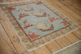 Modern Oushak rug's unique spiral border and blue field with floral motifs.