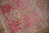 Distressed pink and beige Kars rug pile, showing knot heads and serrate motifs.