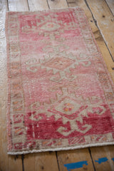 Distressed Kars rug with visible side cord selvage and raspberry red pattern.