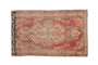 Distressed vintage Dargezine rug with faded cinnabar red and ivory floral medallion, teal accents. 2'4" x 3'9".