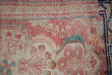 Distressed Dargezine rug texture showing pale cinnabar, ivory, teal floral patterns, and foundation wear.