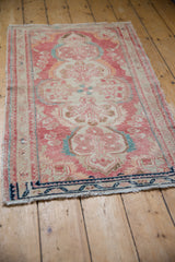 Detail of fringed bottom edge on distressed vintage Dargezine rug with navy border.