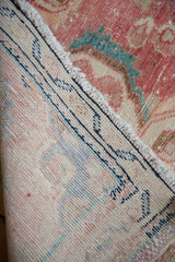Distressed cinnabar red pile, worn fringe, secure edge, and visible foundation of vintage Dargezine rug.