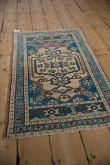 Distressed vintage Oushak rug's cobalt blue geometric starbursts on ivory, with worn pile.