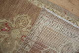 Distressed vintage Oushak rug pile with even wear, revealing hand-knotted foundation.