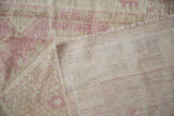 Oushak rug with distressed dusty pink pile revealing its hand-knotted foundation.