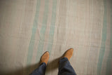 Hand-woven Turkish Kilim rug with horizontal bands in soft beige and seafoam green.