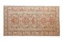 Distressed Kars rug with single column raspberry floral medallions on a muted sage green field.