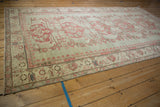 Distressed vintage Kars carpet border showing faded raspberry palmettes and machine bound edge.