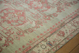 Distressed Kars carpet showing faded raspberry floral motifs, low pile texture, and bound edge.