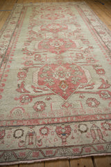 Distressed Turkish Kars rug featuring pale raspberry floral palmettes and visible foundation wear.